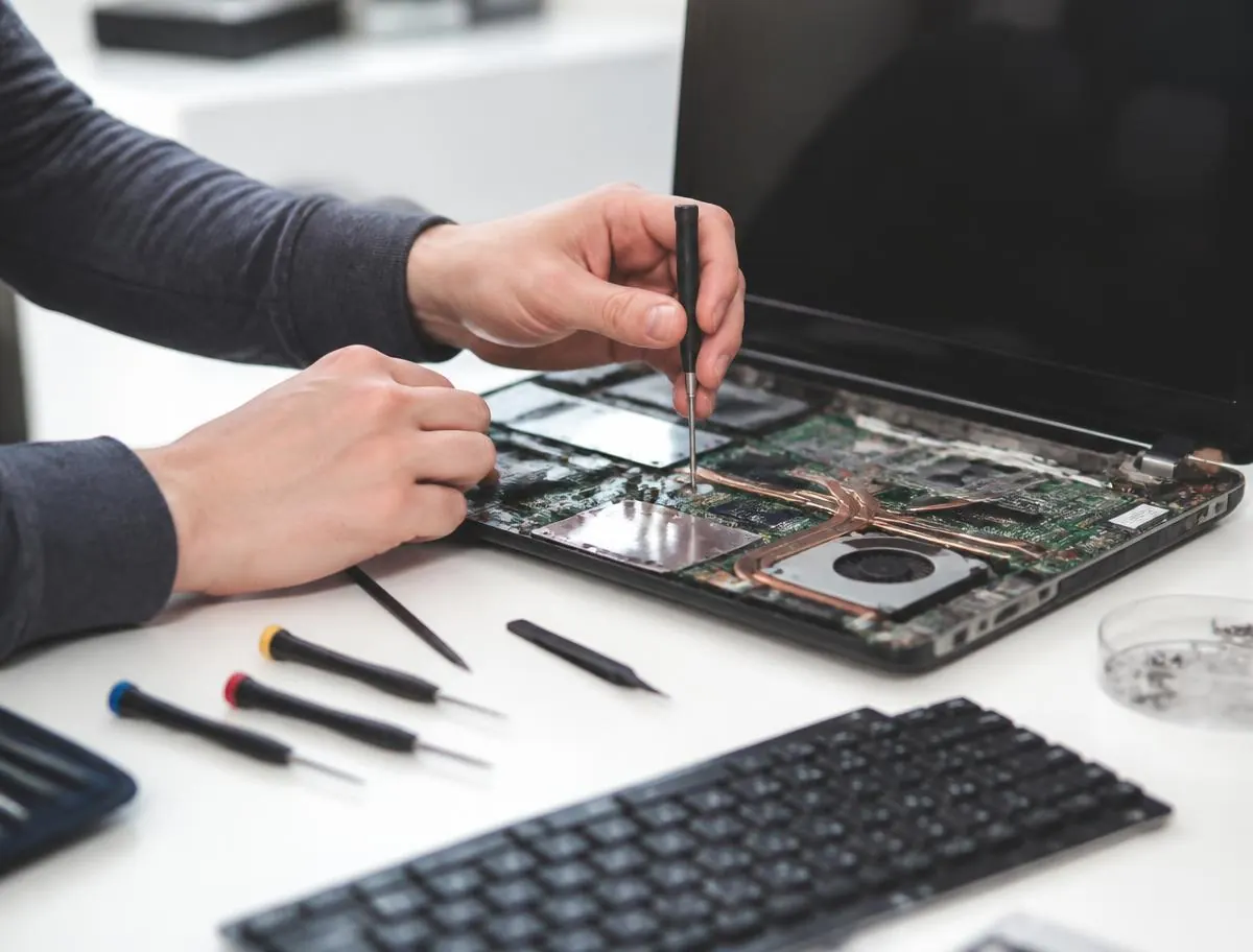 Technician repairing a laptop on a clean workbench for PC Pick N Fix in Vienna, VA